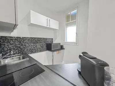 a white kitchen with a sink and a counter at Charmant studio au coeur de Nice in Nice