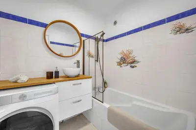 a bathroom with a tub and a sink and a mirror at Bel appartement vue mer proche de la promenade des anglais in Nice