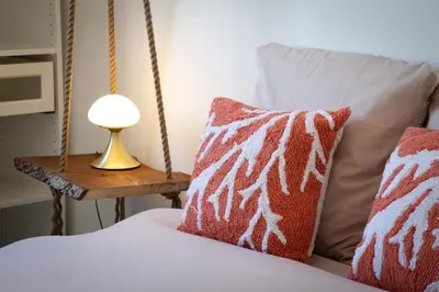 a bed with two pillows and a lamp on a table at Bel appartement vue mer proche de la promenade des anglais in Nice