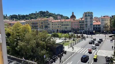 a city street with cars parked in front of buildings at Le Félix in Nice