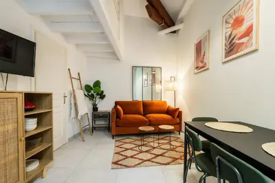 a living room with an orange couch and a table at Jolie duplex avec patio in Nice