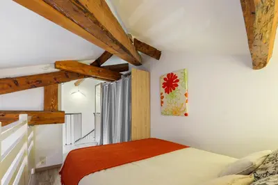 a bedroom with a bed and wooden beams at Jolie duplex avec patio in Nice