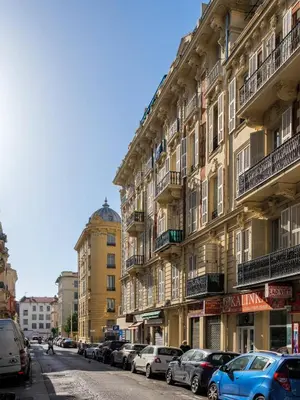 a row of buildings on a street with parked cars at Jolie duplex avec patio in Nice