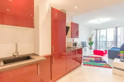 a kitchen with red cabinets and a sink at Nice promenade des anglais vue mer in Nice