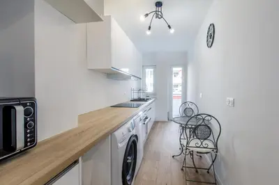 a kitchen with white cabinets and a washer and dryer at 2 Bedroom Ocean view Apartment in Nice