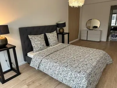 a bedroom with a bed with a black headboard and a mirror at 2 Bedroom Ocean view Apartment in Nice