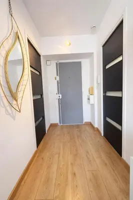 a hallway with black doors and a wooden floor at Smolett 2 Pers Terrazza WiFi in Nice