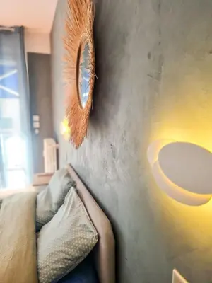 a person laying on a couch with a mirror on a wall at Charmant appartement - Climatisation - Nice in Nice
