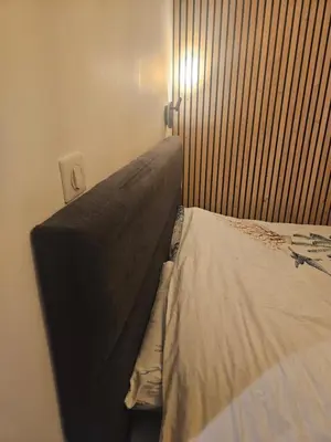 a bed in a bedroom with a light on the wall at L'évidence in Nice