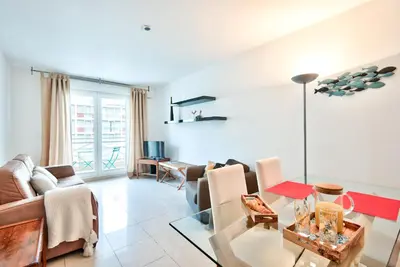a living room with a couch and a table at 2P balcon Vue Mer YourHostHelper 2 mins de la mer in Nice