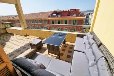 a balcony with couches and tables on a building at 