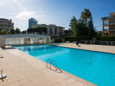 a large swimming pool with a building in the background at Heliotel Marine Studio avec balcon au 4eme étage à 200m de la mer in Saint-Laurent-du-Var