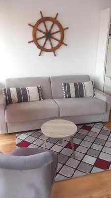 a living room with a couch and a table at Heliotel Marine Studio avec balcon au 4eme étage à 200m de la mer in Saint-Laurent-du-Var