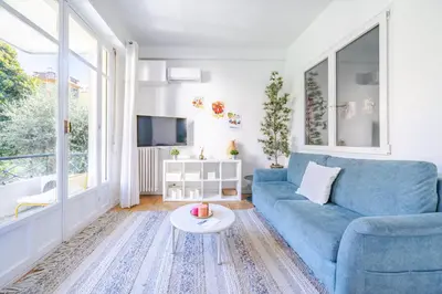 a living room with a blue couch and a table at Charmant 2P au cœur de Nice in Nice