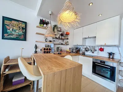 a kitchen with white cabinets and a wooden counter top at Riviera-King-Studio in Villefranche-sur-Mer