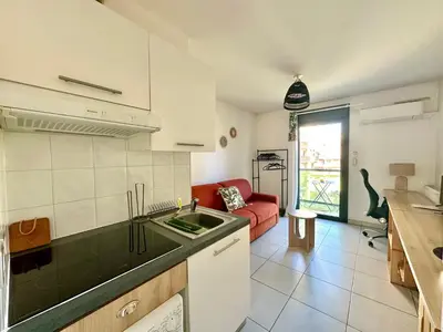 a kitchen and living room with a red couch at Studio 600 m de la Promenade des Anglais in Nice
