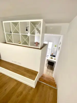 a room with white walls and a staircase with a desk at Studio cosy Nice in Nice