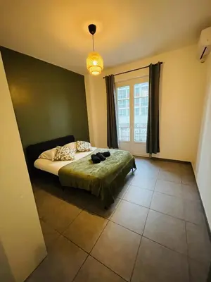 a bedroom with a bed and a large window at Appartement Californie Beach in Nice