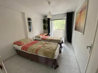two twin beds in a room with a window at Nizza-Azur vue mer in Nice