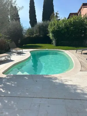 a swimming pool in a yard with a bench and trees at L'olivier in Gattières
