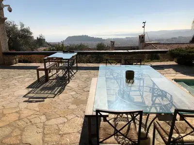 a table and chairs on a patio with a view at Villa loucisa Nice piscine vue mer 8 chambres 24 couchages in Nice