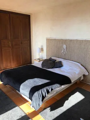 a bedroom with a large bed with a wooden headboard at Villa loucisa Nice piscine vue mer 8 chambres 24 couchages in Nice