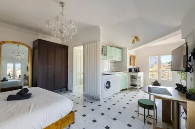 a bedroom with a bed and a table and a kitchen at Perchoir au coeur de Nice in Nice
