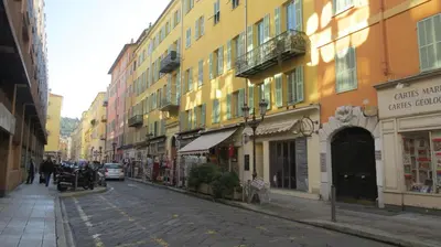 a street in a city with buildings and people walking at Apartment Massena in Nice