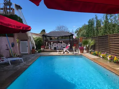 a swimming pool in a backyard with a gazebo at Rez de Jardin Villa Cagnes Sur Mer. in Cagnes-sur-Mer