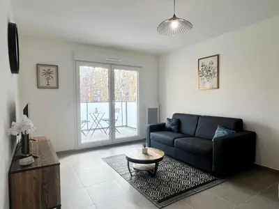 a living room with a couch and a coffee table at Brand new flat with terrace and parc view in Nice