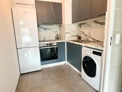 a kitchen with a white refrigerator and a washer at Brand new flat with terrace and parc view in Nice