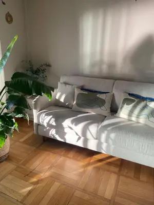 a silver couch in a living room with plants at Nice Promenade des Anglais Your Seafront Flat in Nice