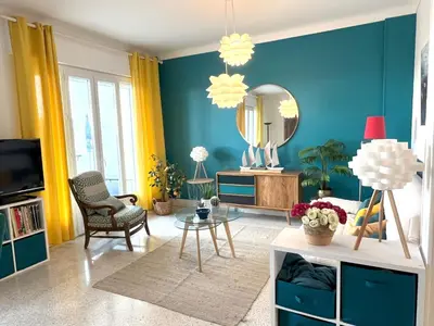 a living room with blue walls and a mirror at Terrace and view on all Nice city in Nice
