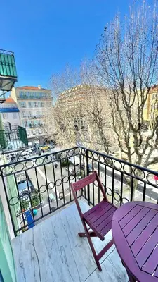 a purple chair and a table on a balcony at Place Grimaldi, close to beach and restaurants, with balcony in Nice