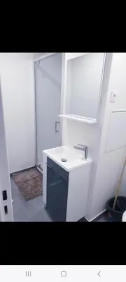 a white bathroom with a sink and a mirror at Grand Appartement 5 chambres, 5 télévision , 95 m2, vue mer, tramway sur place, gare train 2 min, aéroport 5 min , Large Apartment 5 bedrooms, 5 televisions, 95 m2, sea view, tram on site, train station 2 mins, airport 5 mins in Nice