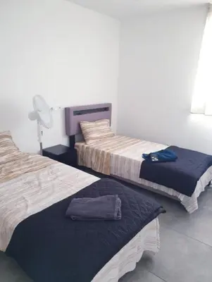 a room with two beds and a pillow on the floor at Grand Appartement 5 chambres, 5 télévision , 95 m2, vue mer, tramway sur place, gare train 2 min, aéroport 5 min , Large Apartment 5 bedrooms, 5 televisions, 95 m2, sea view, tram on site, train station 2 mins, airport 5 mins in Nice