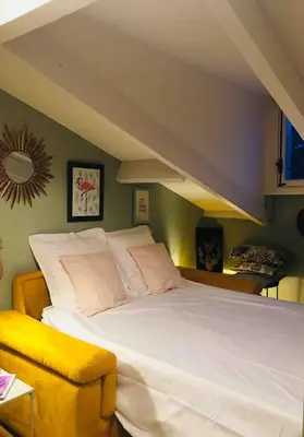 a bedroom with a large white bed and a yellow chair at Charming flat - Nice port in Nice