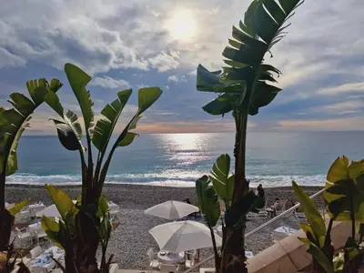 a view of the ocean from a beach with umbrellas at Syrah - Cozy Apartment in Nice
