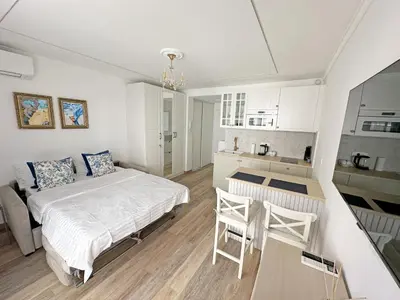 a white bedroom with a bed and a kitchen at Stunning Studio Rue France Promenade des Anglais in Nice