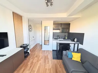 a living room with a couch and a kitchen at Studio au cœur de Nice lumineux in Nice