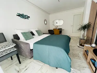 a bedroom with a large bed and a couch at Superbe appartement Port de Nice Lumineux,Clim , Parking in Nice