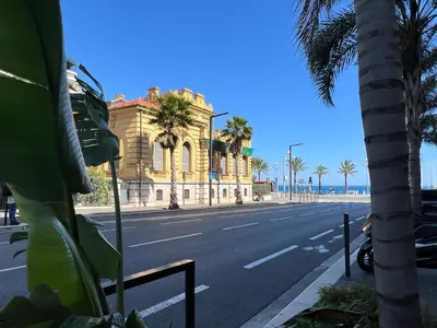 a building with palm trees on the side of a street at Studio toit terrasse vue mer Sea View in Nice