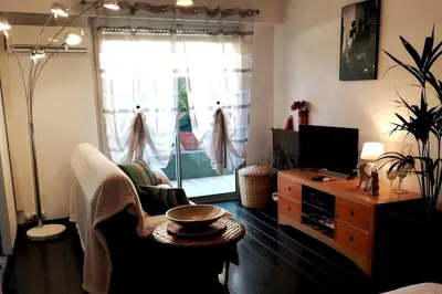 a living room with a couch and a tv at Cosy F1 avec grande terrasse à 2 pas du tramway in Nice