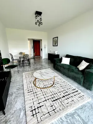 a living room with a green couch and a table at Le Grand Soleil in Nice