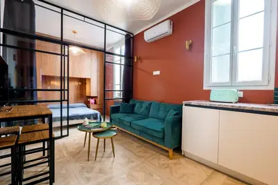 a living room with a green couch and a table at Le Jasmin - Au Coeur de Nice in Nice