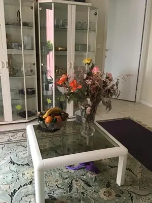 a table with a vase of flowers and a bowl of fruit at Nice port quartier antiquaire in Nice