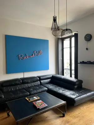 a black leather couch in a living room with a table at loft riviera in Nice