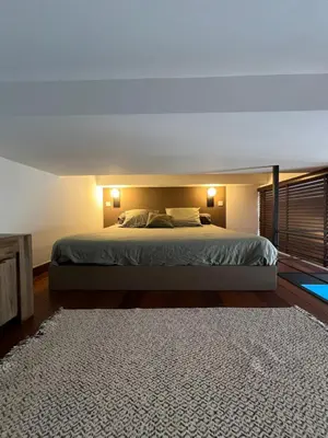 a bedroom with a bed with two lamps and a rug at loft riviera in Nice