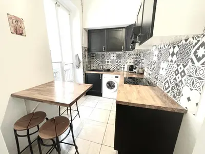 a kitchen with a counter and stools in it at Cosy Family trip in Nice