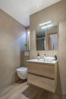 a bathroom with a sink and a toilet and a mirror at Guest House Chez Bastien in Nice
